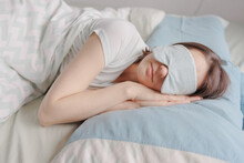 Woman In A Sleep Mask Is Lying In Bed And Sleeping. A Happy European Woman With Mental Health And Sound Sleep Or With Sleep Problems And Insomnia Falling Asleep In A Cozy House. Sleep Disorders Or