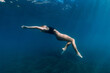Woman posing underwater in blue ocean. Beautiful lady in bikini undewater