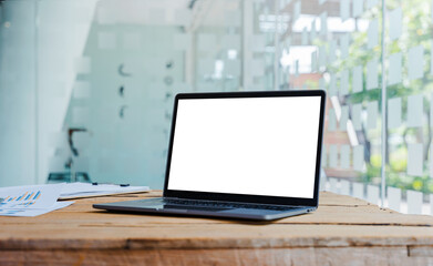 Laptop with blank white screen on wooden table for montage your ads.