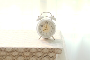 good morning concept  modern alarm clock and houseplant on bedside table,Alarm clock on wooden table with blurred background