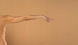 © vladimirfloyd - Young woman's stretched arm and touching imaginary product with index finger. Isolated on beige background