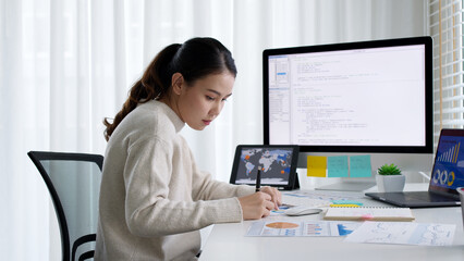 Asia young business woman sit busy at home office desk work code on desktop reskill upskill for job career remote self test IT deep tech ai design skill online html text for cyber security workforce.