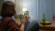 © ChayTee - Young happy attractive asia female enjoy relax night party event online celebration festive with friends at home sofa pr table clinking beer with glass and bottle drinking via online videocall.
