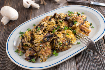 Wall Mural - Scrambled eggs with mushrooms, onions and scallion on a palte