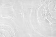 © Aleksandra Konoplya - Desaturated transparent clear water surface texture with ripples, splashes Abstract nature background. White-grey water waves overlay Copy space, top view. Cosmetic moisturizer micellar toner emulsion