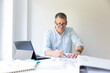 © epiximages - Business portrait of architect sitting at his work table and planning in his modern bright office
