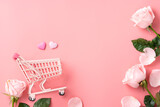 Fototapeta Kwiaty - Mother's Day shopping design concept background with pink rose flower and cart on pink background.