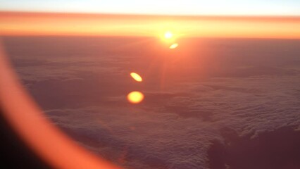 Wall Mural - 4k handheld video footage of magic moments of sunrise time as seen through glass of flying airplane.