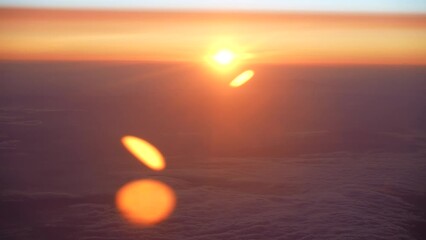 Wall Mural - 4k handheld video footage of magic moments of sunrise time as seen through glass of flying airplane.