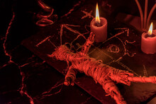Voodoo Doll, Black Candles, Pentagram And Old Books On Witch Table. Occult, Esoteric, Divination And Wicca Concept. Mystic, Voodoo And Vintage Background.