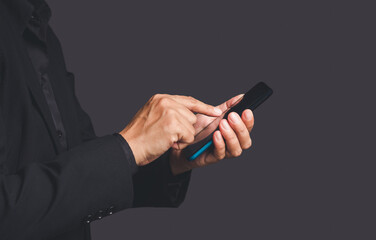 Wall Mural - close-up of hands businessman in a suit using a mobile phone while standing over a gray background