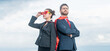© Olena - successful business couple in superhero suit on sky background