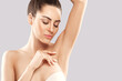 Armpit epilation, lacer hair removal. Young woman holding her arms up and showing clean underarms, depilation  smooth clear skin.