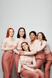 © Mediaphotos - Group of cheerful multi-ethnic women having close connection embracing each other against white wall