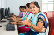 Smiling women showing thumbs up by looking camera during computer training class - concept of women employment, learning and education