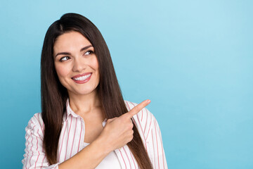 Poster - Portrait of attractive curious cheerful long-haired girl demonstrating copy space ad isolated over blue pastel color background