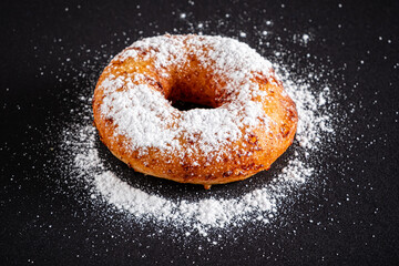 Wall Mural - Sugar donut on a black background