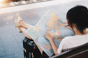 Back side of traveler girl searching right direction on map, traveling along asian by train, freedom and active lifestyle concept