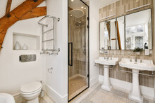 Interior Of Stylish Bathroom With Shower Cabin And White Ceramic Sinks