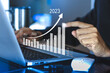 © surachat - Businessman using a computer show plan business growth and financial, increase of positive indicators to increase business growth and an increase for growing up business from year 2021-2023