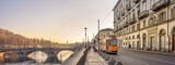Turin, Italy. February, 15, 2022. View at sunset on the Po river In the distance the ancient Vittorio Emanuele I bridge and a tram passing in Lungo Po Luigi Cadorna street. Banner header.