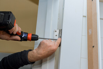 Sticker - Renovation apartment with door frame installation the master installs the door and screw the hinge a screwdriver