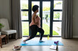 © Wavebreak Media - Side view of african american mid adult woman exercising on yoga mat at home