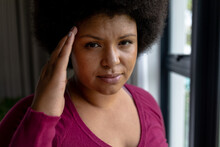 Close-up Of African American Mid Adult Woman Touching Head While Standing By Window At Home