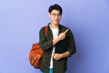 Young student woman isolated on purple background pointing to the side to present a product