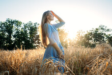 Connect With Nature, Slow Down, Be Present, Get Into Your Senses. Peaceful Alone Young Woman In Dress Walking On Wheat Field At Sunset Summer Day