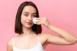 © luismolinero - Young Ukrainian woman isolated on pink background with cotton pad for removing makeup from her face