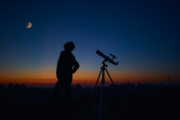 Wall Mural - silhouette of a man and telescope under the starry skies.