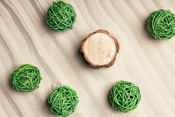 Canvas Print - green balls on the sand and a stump, top view