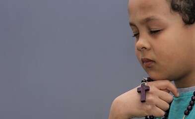 Sticker - boy praying to God with hands held together with closed eyes on white background stock photo