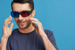 © SHOTPRIME STUDIO - Cheerful man Cheerful man in cinema glasses in a t-shirt blue background