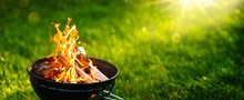 Barbecue Grill With Open Fire On Green Grass Background. Fire Flame