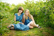 © MNStudio - Cute young sisters picking fresh berries on organic blueberry farm on warm and sunny summer day. Fresh healthy organic food for kids.