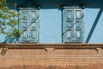 Sticker - Old rustic country house with a blue-painted wall and closed shutters