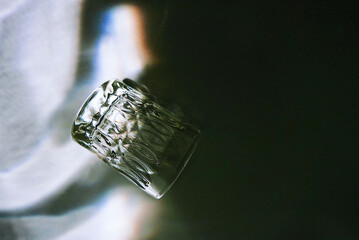 Wall Mural - Closeup shot of glass lying on its side with shadow in dark background