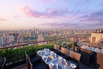 Wall Mural - Table setting on roof top restaurant with megapolis view, Bangkok Thailand.