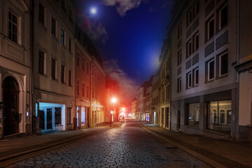 Wall Mural - Street of an old European city with paving stones at night with street lamps and blue sky