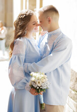 A Loving Couple In Blue Embroidered Suits Hug Each Other.
