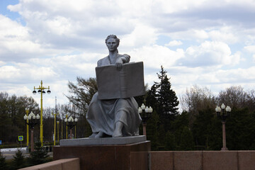 Sculpture of a seated woman with a book