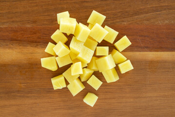 Wall Mural - raw sliced potatoes on on wooeden cutting board background.