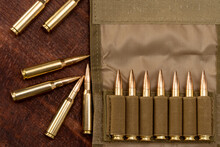 Military Bandolier With Yellow 7.62 Caliber Cartridges On A Wooden Background.