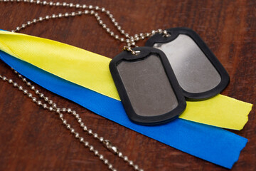 Army identification badges and yellow-blue ribbons of the Ukrainian flag on a textured background. Concept: service in the Ukrainian army, mobilization in Ukraine, the war for freedom.