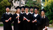 © spoialabrothers - Group of multiracial graduates students posing happy in front of the camera in the graduation day holding diplomas they posing in the college park