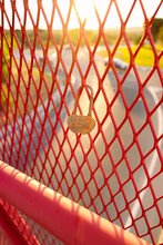 Closeup Of Padlock With ""TE AMO" Phrase Hanging On The Red Mesh Grid Fence