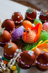 Wall Mural - Closeup shot of decorated eggs for Easter on round wooden Easter egg storage rack