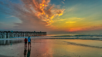 Couple walking on Flagler Beach at sunset in Florida